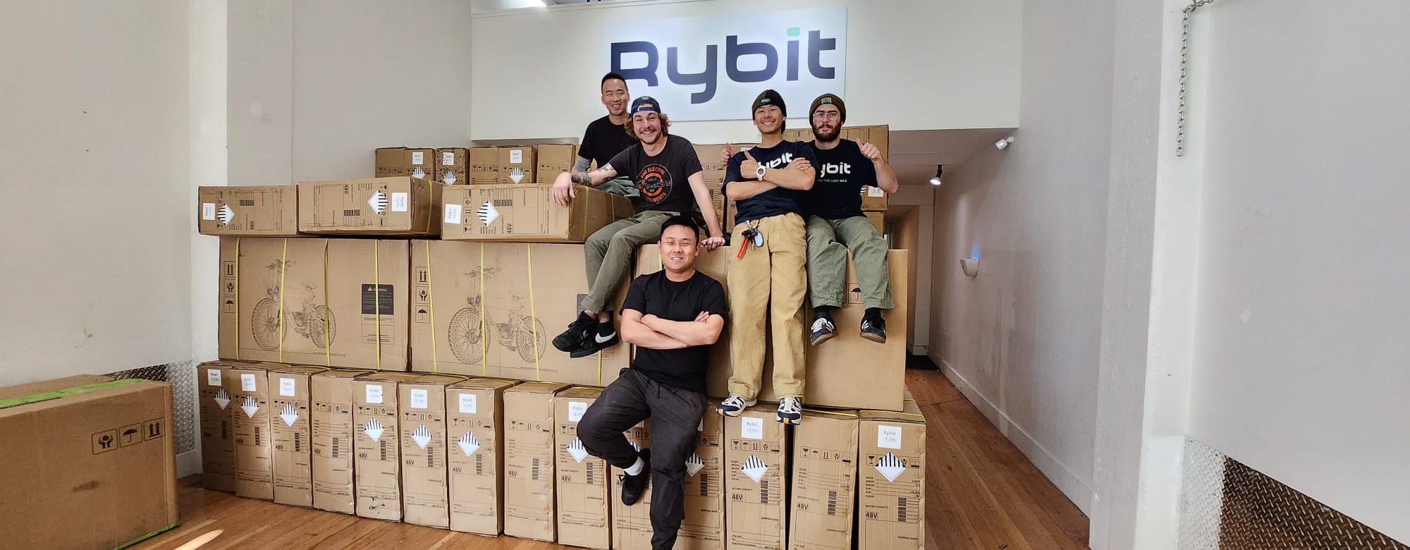 Kai with the Rybit operations team and boxed e-bikes in the United States